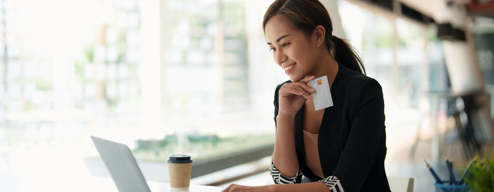 Close up of black girl hold bank credit card and type on laptop, shopping online using computer, buying goods or ordering online, entering bank accounts and details in online banking offer.