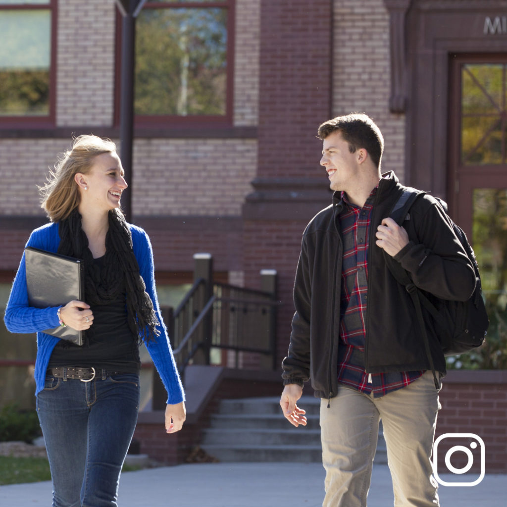 Two students walking and talking on campus