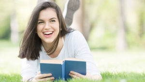 Young woman reading a book outside