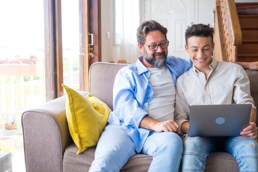 Photo of a father and son looking at a laptop
