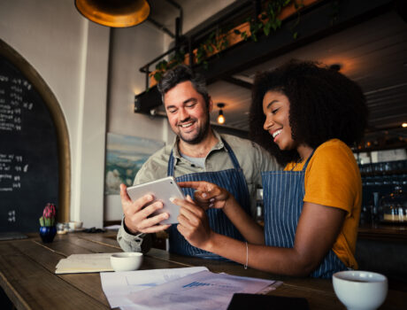 Manager,And,Waitress,Laughing,At,Designs,On,Digital,Tablet,Standing