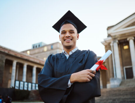 University, graduation and happy man with a diploma scroll standing outdoor of his campus. Education, scholarship and male graduate from Mexico with academic certificate or degree for college success