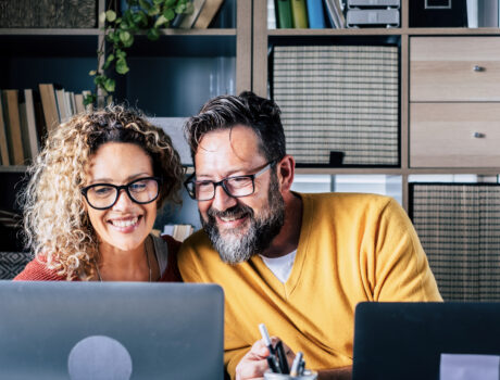 Happy adult couple work at home together with video conference computer